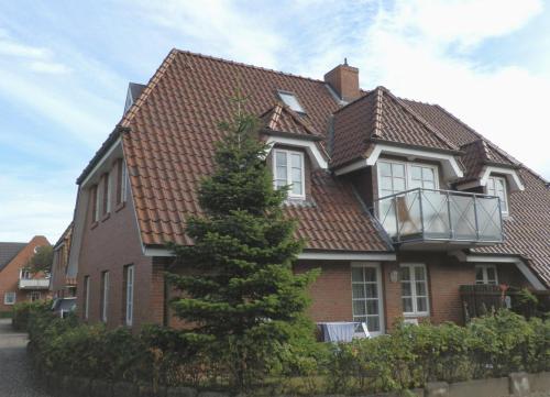 uma casa com uma árvore em frente em Navigare em Wyk auf Föhr