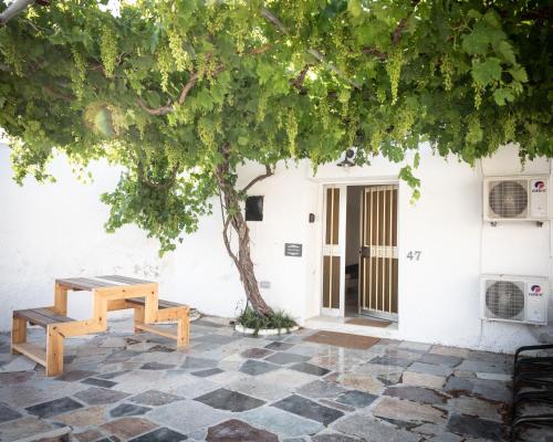 un tavolo da picnic e un albero di fronte a un edificio di LIMASSOL AKROTIRI VINE COTTAGE a a Limassol