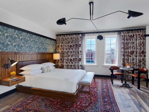 - une chambre avec un grand lit blanc et un bureau dans l'établissement Hotel Revival Baltimore, à Baltimore