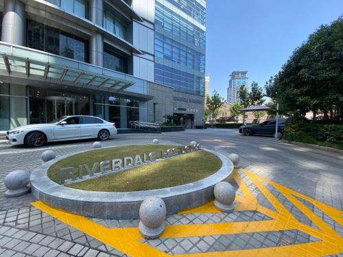 um carro branco estacionado em frente a um edifício em Riverdale Residence Xintiandi Shanghai em Xangai