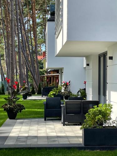 un patio con sillas y plantas en Apartamenty Marco Polo, en Dziwnówek