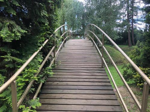 een houten brug over een veld met bomen bij Hotel Zameczek in Radomsko