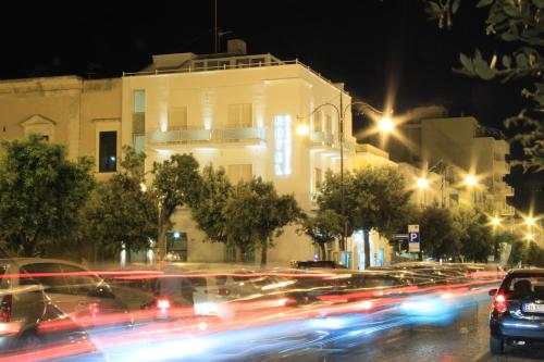 nachts eine Stadtstraße mit Autos und Gebäuden in der Unterkunft Hotel Città Bella in Gallipoli