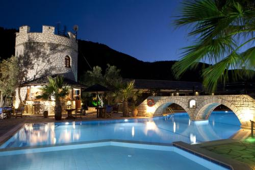 uma piscina em frente a um castelo à noite em Villa Elia Resort em Lefkada Town