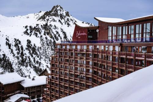 un hotel nella neve con una montagna sullo sfondo di Belambra Clubs Arc 2000 - L'Aiguille Rouge - Ski pass included ad Arc 2000