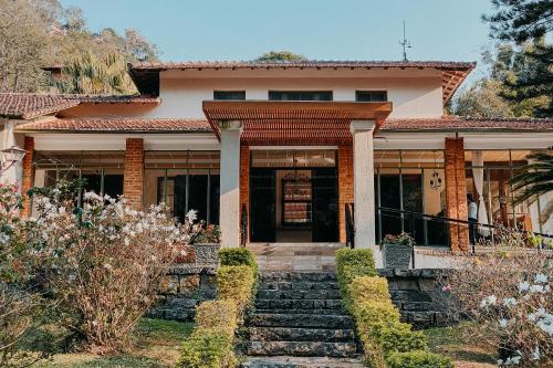 une maison avec des escaliers menant à la porte d'entrée. dans l'établissement Hotel Vila Bavária Petrópolis, à Petrópolis