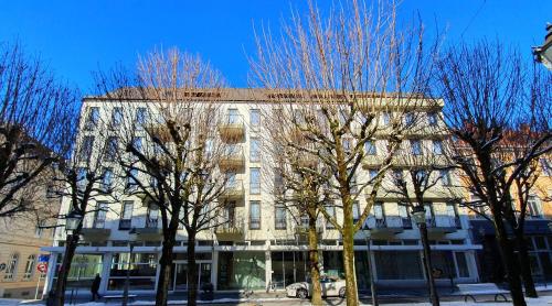 un edificio alto con alberi di fronte di Hotel Quellenhof a Baden-Baden