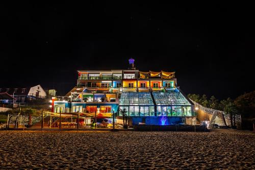 un gran edificio iluminado por la noche en UnderSun Spa Hotel, en Grybivka