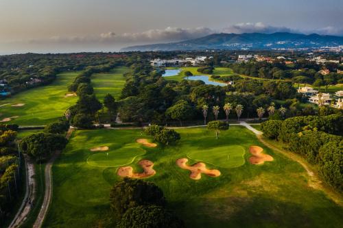 - une vue aérienne sur un parcours de golf avec des arbres et une rivière dans l'établissement Onyria Quinta da Marinha Hotel, à Cascais