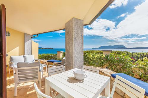 un patio con mesa y sillas y vistas al océano en Terrazza su Tavolara, en Olbia