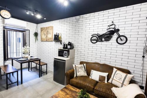 uma sala de estar com um sofá e uma moto na parede em Apartamentos turísticos MAJMA em Cáceres