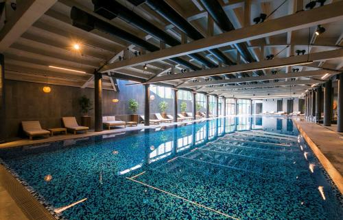 een groot zwembad met blauw water in een gebouw bij Radisson Blu Hotel Sopot in Sopot