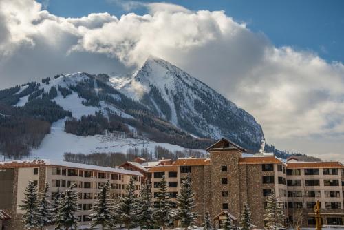 The Grand Lodge Hotel and Suites في Mount Crested Butte: مبنى في خلفية جبل