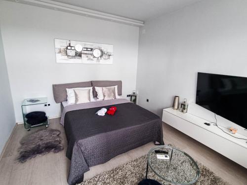 a bedroom with a bed and a flat screen tv at Apartment Apex penthouse self check-in in Karlovac