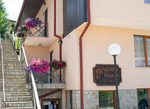 un bâtiment avec des fleurs sur les fenêtres et une lumière de rue dans l'établissement Rodopi Houses, à Chepelare