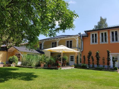 een huis met een paraplu in de tuin bij Pension Diener in Naußlitz