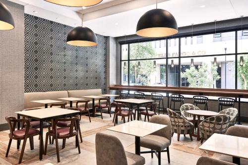 a restaurant with tables and chairs and windows at Hyatt Place Phoenix/Downtown in Phoenix