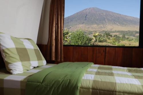 een slaapkamer met een bed en uitzicht op een berg bij The Gate Rinjani in Sajang