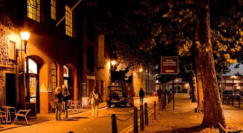 a person walking down a city street at night at YHA Bristol in Bristol