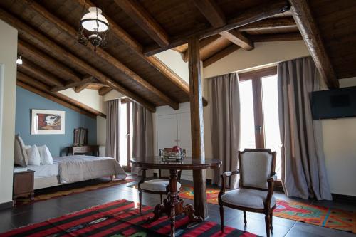 a bedroom with a bed and a table and a chair at Ellinon Thea Arachova in Arachova