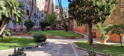 eine Straße in einer Stadt mit Palmen und Gebäuden in der Unterkunft R.&T. Suite House Roma in Rom