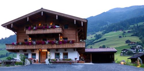 um edifício com uma varanda com flores em Ferienwohnung Lerchenhof em Wald im Pinzgau