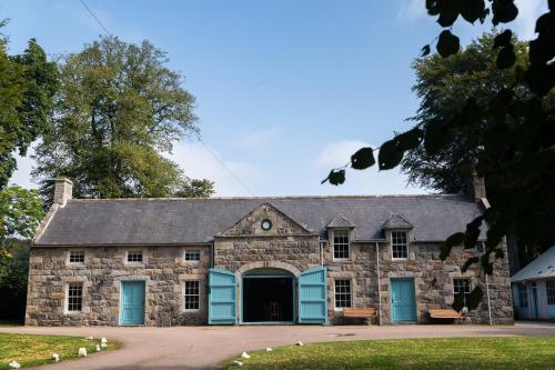 een oud stenen gebouw met blauwe luiken erop bij Netherdale House & The Coach House in Turriff