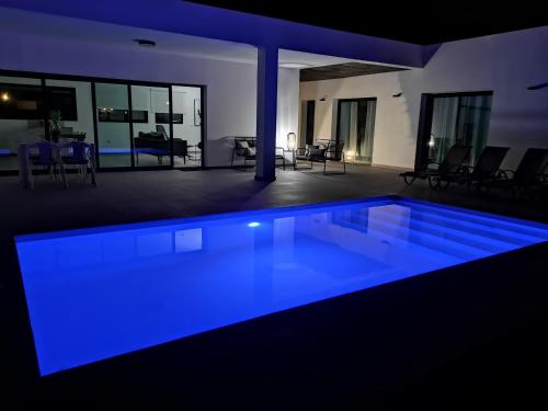 una piscina con illuminazione blu in una casa di Villa Montaña Colorada a Lajares