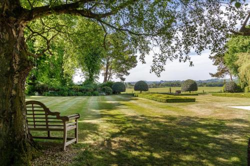 a bench sitting under a tree in a park at Self contained accommodation near Delamere forest in Oakmere