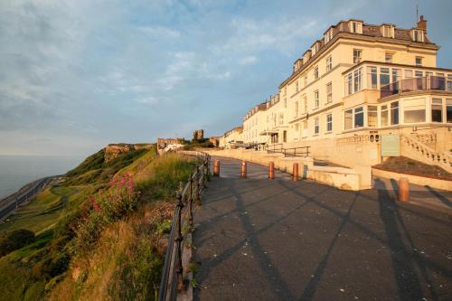 um edifício ao lado de um penhasco ao lado do oceano em The Norbreck Hotel by Compass Hospitality em Scarborough