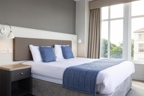 um quarto de hotel com uma cama grande e uma janela em The Norbreck Hotel by Compass Hospitality em Scarborough