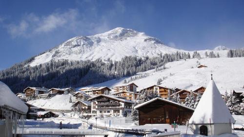 a snow covered mountain in front of a ski lodge at Haldenhof in Lech am Arlberg