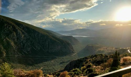 vista su una valle con il sole che splende su una montagna di Acropole Delphi City Hotel a Delfi