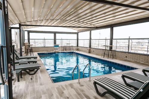 una gran piscina con sillas en un edificio en Noor Land Hotel, en Baghdād