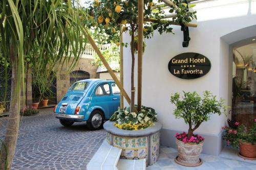 een blauwe auto geparkeerd voor een gebouw bij Grand Hotel La Favorita in Sorrento