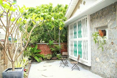 une terrasse avec des chaises, une fenêtre et des arbres dans l'établissement Tainan MacArthur Homestay, à Tainan