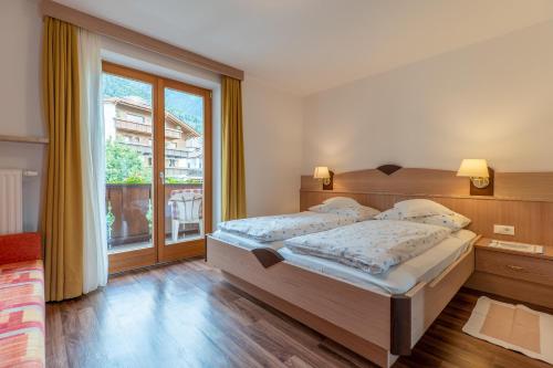 1 dormitorio con 2 camas y ventana grande en Wiesengrund - Wohnung 5, en Tirolo