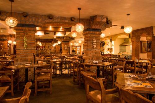 een restaurant met tafels en stoelen en een bakstenen muur bij Hotel María Bonita Consulado Americano in Ciudad Juárez