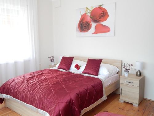 a bedroom with a bed with a red comforter at Bogácsa Apartman in Bogács