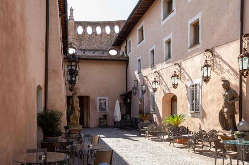 une allée avec des tables et des chaises dans un bâtiment dans l'établissement Il Monastero Collection, à Rome