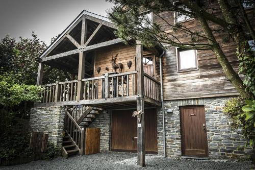 Cette grande maison en bois possède un balcon. dans l'établissement Saint-Hubert d'Ardenne, à Hatrival