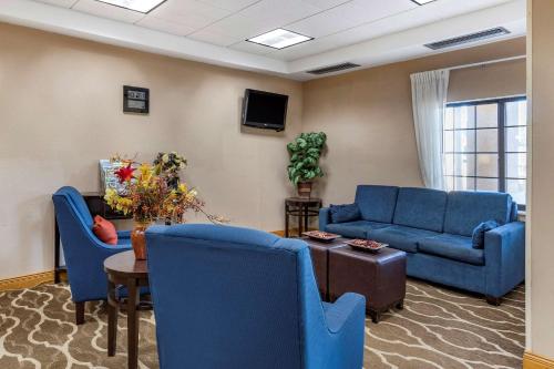 a living room with blue chairs and a couch and a table at Comfort Inn Downtown - University Area in Kalamazoo