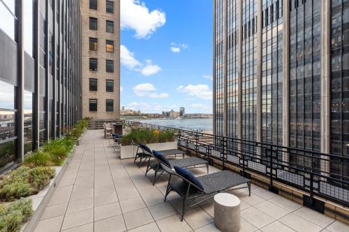 a balcony with benches and a view of the water at Placemakr Wall Street in New York