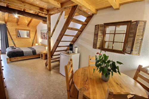 a room with a wooden table and a bedroom at Les Balcons du Molliebon in Séez