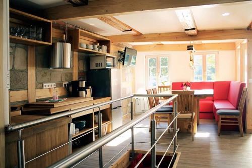 Cette chambre dispose d'une cuisine avec des chaises rouges et une table. dans l'établissement Ferienhaus Schloßblick, à Quedlinbourg