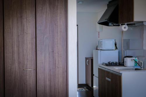 a kitchen with a white refrigerator and a microwave at Blue Entrance in Onna