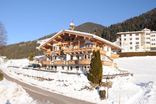 un gran edificio de madera en la nieve en Hotel Landhaus Marchfeld, en Oberau