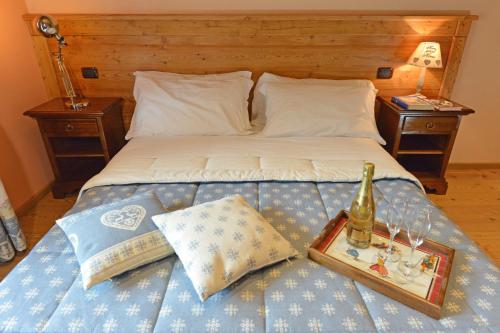 a bed with a bottle of wine and a tray on it at Miravalle in Antey-Saint-André