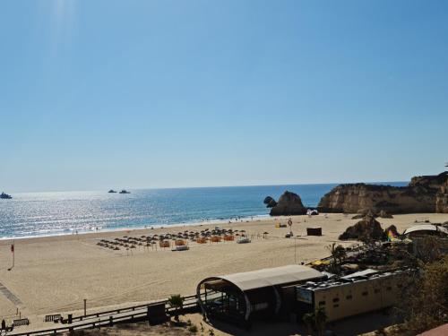 uma praia com guarda-sóis e pessoas na praia em Portugal Algarve Beach Apartment em Portimão