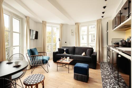 sala de estar con sofá y mesa en My Maison In Paris - Louvre, en París